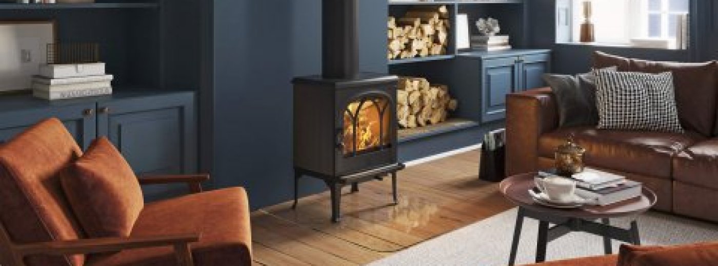 Jøtul F 200 żeliwny piec na drewno w salonie z ciemnoniebieskimi ścianami