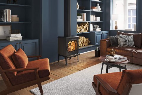 Jøtul F 200 żeliwny piec na drewno w salonie z ciemnoniebieskimi ścianami