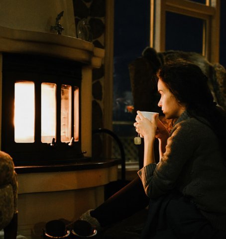 Kobieta siedząca wieczorem przed kominkiem